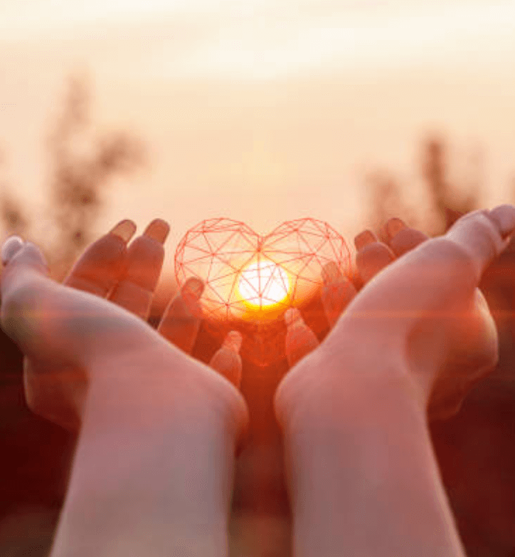 Twee handen die symbolisch een hart dragen met de zon op de achtergrond